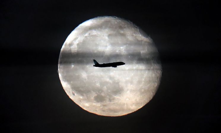보름달 앞을 비행 중인 여객기. 달의 하루는 29.5일입니다. [사진=EPA/연합뉴스]