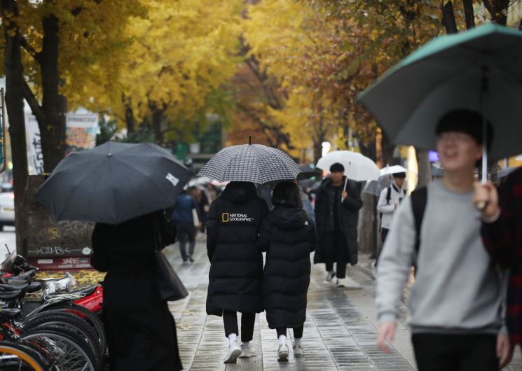 중부지방에 약한 비가 내린 지난달 24일 오후 서울 마포구 홍대입구역 인근에서 시민들이 우산을 쓰고 비를 피하고 있다. / 사진=연합뉴스