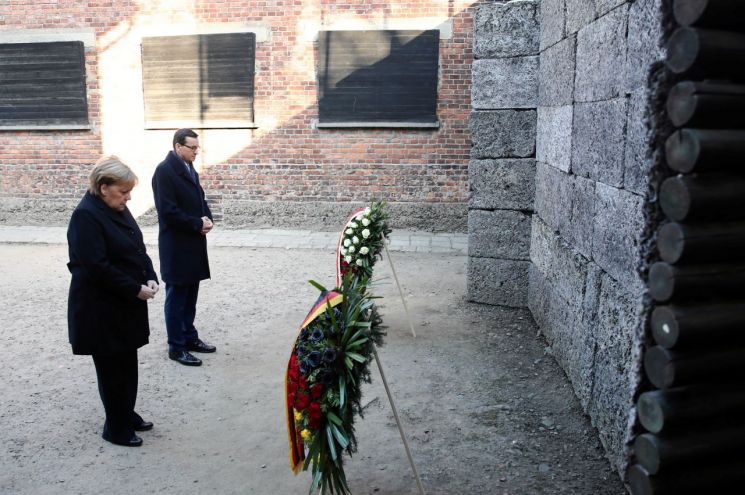 앙겔라 메르켈 독일 총리(왼쪽)가 마테우시 모라비에츠키 폴란드 총리(오른쪽)과 함께 6일(현지시간) 폴란드 아우슈비츠 나치 강제 수용소를 방문해 헌화하고 있다. / 사진=연합뉴스