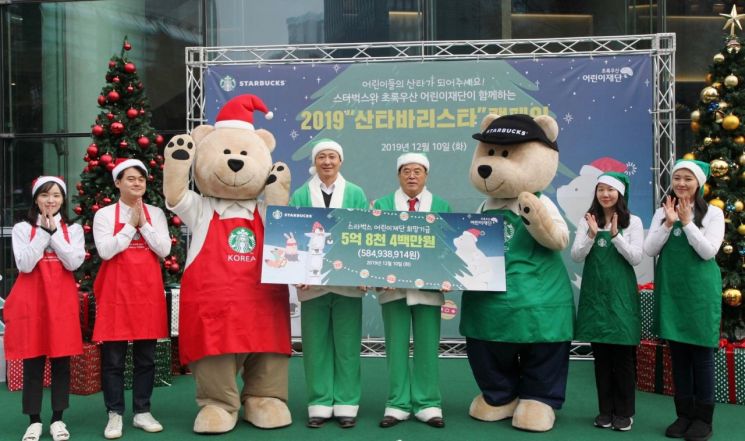 송호섭  스타벅스 대표이사(왼쪽에서 네 번째)가 이제훈 초록우산 어린이재단 회장(왼쪽에서 다섯 번째)에게 2019 산타 바리스타 기금을 전달하고 있다.