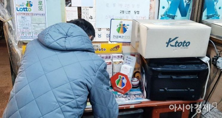 한 로또 판매소에서 한 시민이 수동으로 로또 번호를 써놓고 있다. 사진=한승곤 기자 hsg@asiae.co.kr