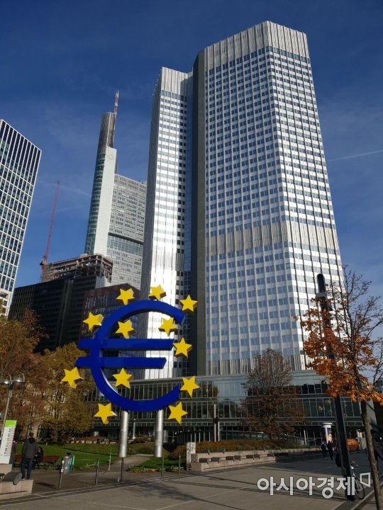 독일 프랑크푸르트 금융중심지구에 있는 유로화 조형물 뒤로 유럽중앙은행(ECB) 건물이 들어서 있다. 왼쪽 뒤편에는 코메르츠방크 빌딩이 자리하고 있다.