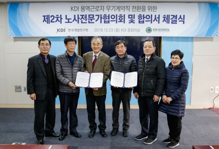 최정표 KDI 원장(왼쪽세번째)이 다섯 명의 용역근로자 위원들과 노사합의 체결식을 마치고 기념촬영을 하고 있다.