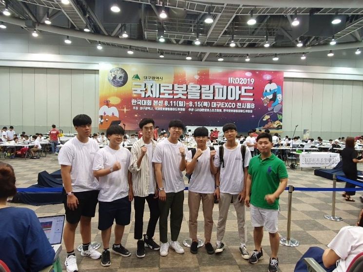 전북기계공고 2학년에 재학 중인 전민건 학생(오른쪽 두 번째)이 국제로봇올림피아드 세계대회 참가를 위한 한국대회 본선장에서 동료들과 기념촬영을 하고 있다./사진제공=전북기계공고