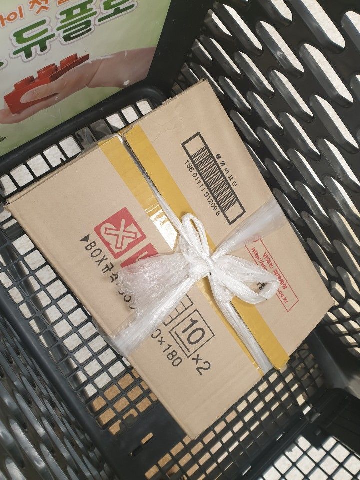 이마트 신도림점 자율포장대에서 만난 한 남성이 자신이 직접 집에서 가져온 노끈 대용품으로 종이상자를 조립한 모습.