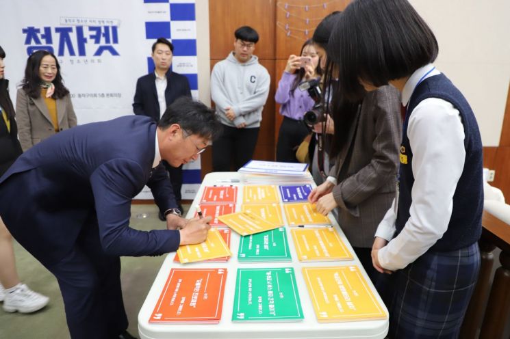 이창우 동작구청장(왼쪽)이 지난해 11월8일 개최한 제1회 청소년 자치 정책마켓에서 '청소년 정책 실현협약서'에 서명하고 있다.