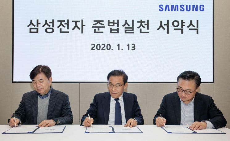 13일 수원 삼성 디지털시티에서 열린 '삼성전자 준법실천 서약식'에 참석한 삼성전자 경영진이 서약서에 서명하고 있다. 사진 왼쪽부터 김현석 삼성전자 사장, 김기남 삼성전자 부회장, 고동진 삼성전자 사장.