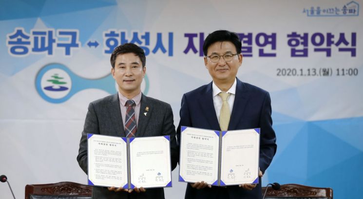 박성수 송파구청장(오른쪽)이 13일 청사 대회실에서 열린 송파구 성시 자매결연식에서 협약 체결후 서철모 화성시장과 기념 촬영을 하고 있다.