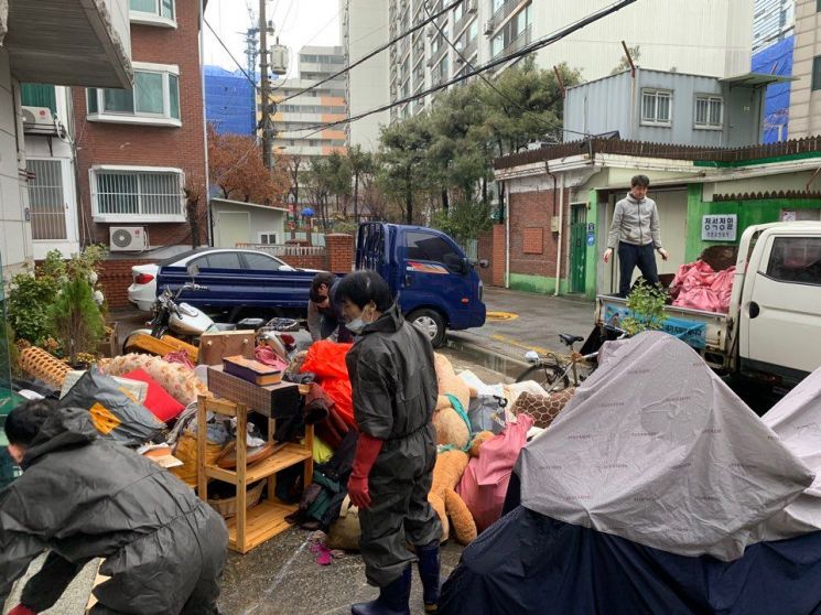 쓰레기로 가득 차 있는 K씨 집을 청소하고 있는 모습
