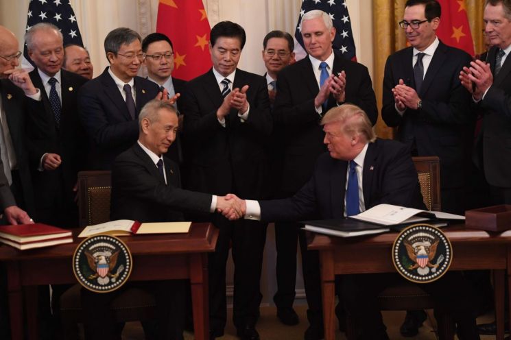 도널드 트럼프 미국 대통령(오른쪽)과 류허 중국 부총리가 15일(현지시간) 워싱턴DC 백악관에서 미중 1단계 무역합의안에 서명한 뒤 악수하고 있다. (사진=AFP연합뉴스)