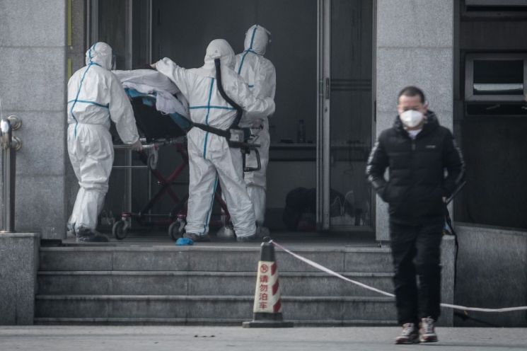 신종 코로나바이러스로 인한 '우한 폐렴'이 발생한 중국 후베이성 우한에서 18일 의료진이 폐렴 환자들을 집중 치료하고 있는 한 병원으로 환자를 옮기고 있다.<이미지출처:연합뉴스>