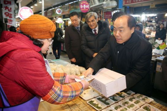 조봉환 소상공인시장진흥공단 이사장(오른쪽)이 20일 대전중앙시장에서 상인에게 온누리상품권을 주면서 떡을 구매하고 있다.