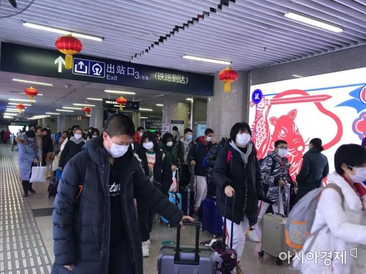21일 오후 5시50분 우한에서 출발한 기차가 베이징서역에 도착하자 우한에서 온 많은 사람들이 마스크를 쓴 채 출구를 빠져나오고 있다.