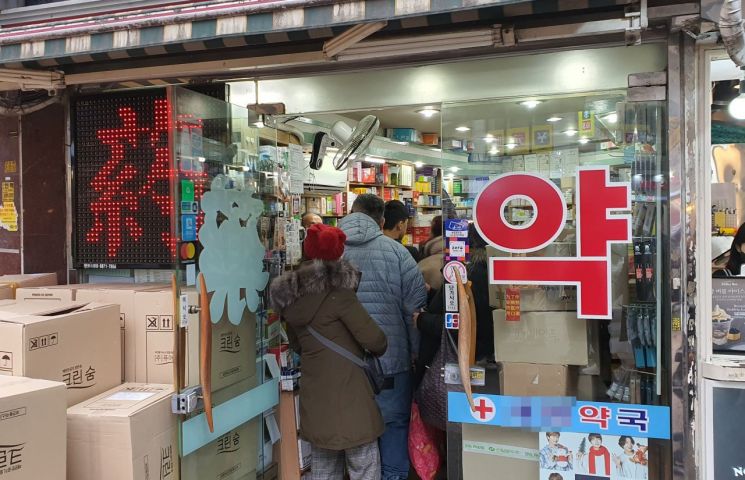 27일 오후 서울 명동의 한 약국에 마스크를 사기 위한 이들이 줄을 서서 기다리고 있다.