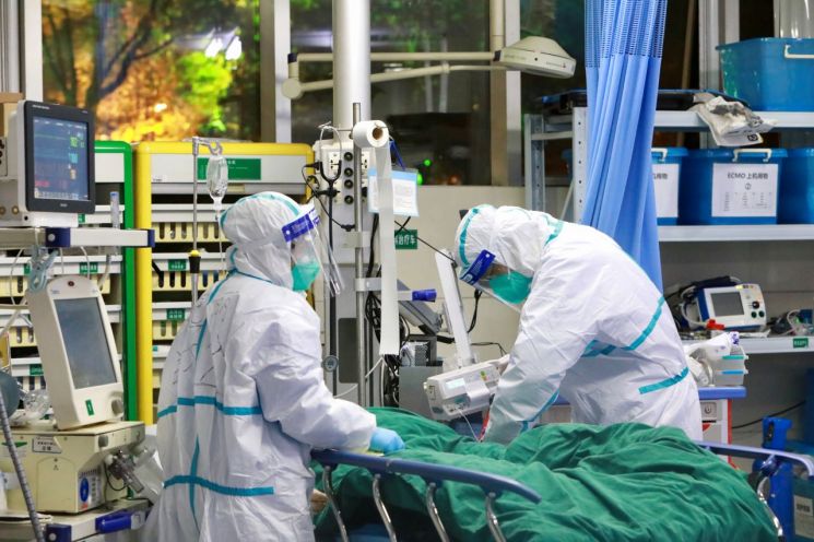 지난 28일 중국 후베이성 우한의 우한대학 부속 중난병원에서 보호복을 입은 의료진이 신종 코로나바이러스에 의한 폐렴 환자를 치료하고 있다. [이미지출처=연합뉴스]