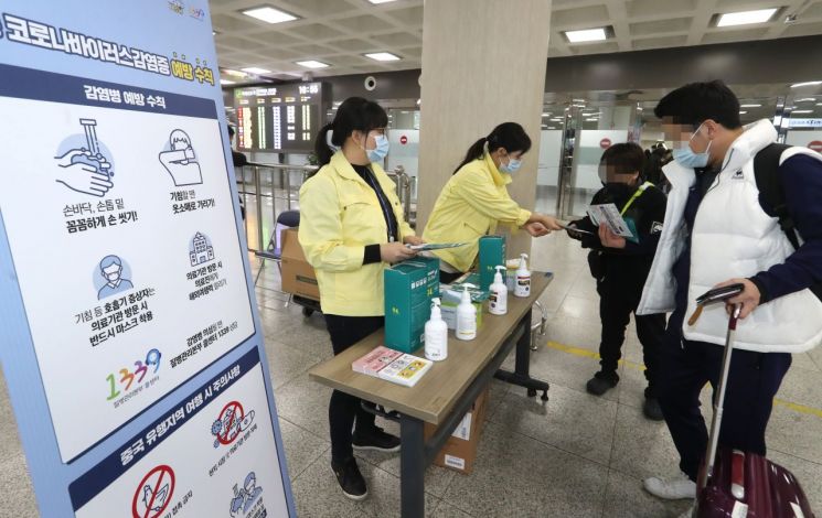 제주도 보건당국 관계자들이 28일 오전 제주국제공항 국내선 도착층에서 신종 코로나바이러스 감염 예방을 위해 마스크 등을 나눠주고 있다. [이미지출처=연합뉴스]