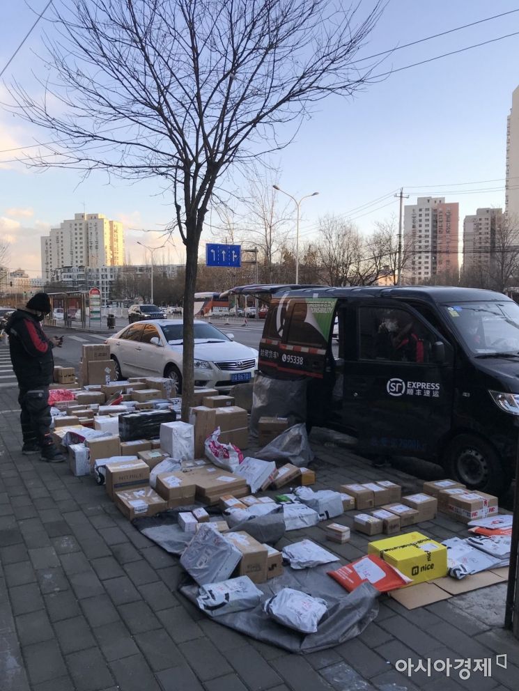 3일 베이징에서 신종 코로나 확산으로 '출입금지'된 택배 기사들이 도로에 택배상자와 우편물을 펼쳐놓고 수령자를 기다리고 있다.