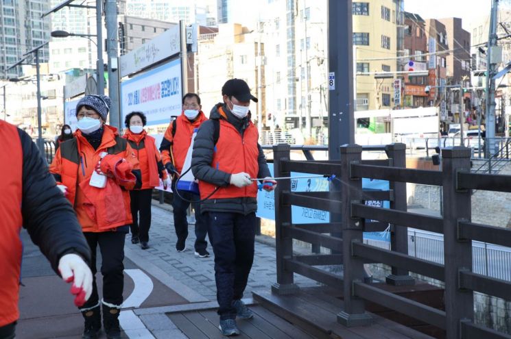 5일 성북천 일대에서 펼쳐진 ‘신종 코로나바이러스 집중 방역’에서 새마을지도자성북구협의회 한 회원 분무 소독을 하고 있다.