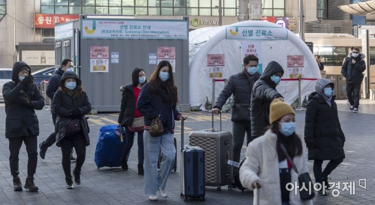 지난 9일 서울 명동 쇼핑거리에 설치된 신종 코로나바이러스 감염증 선별진료소 앞을 마스크를 착용한 외국인 관광객들이 지나가고 있다./윤동주 기자 doso7@