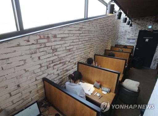 서울의 한 커피숍에서 손님들이 1인용 테이블에 앉아 있다/사진=연합뉴스