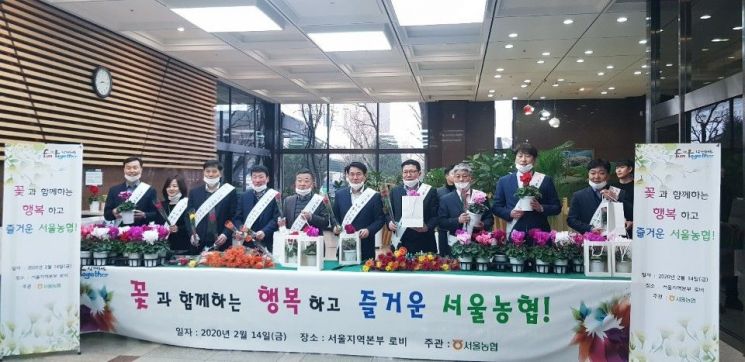 꽃 나눔 행사에 동참한 서울농협 임직원들이 기념촬영을 하고 있다.