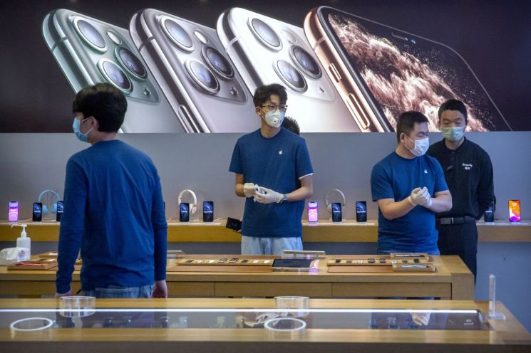 베이징 소재 애플 스토어 직원들이 마스크를 쓴 채 근무하고 있다. 이 매장은 코로나19 영향으로 문을 닫았다가 최근 영업을 재개했다. [이미지출처=AP연합뉴스]