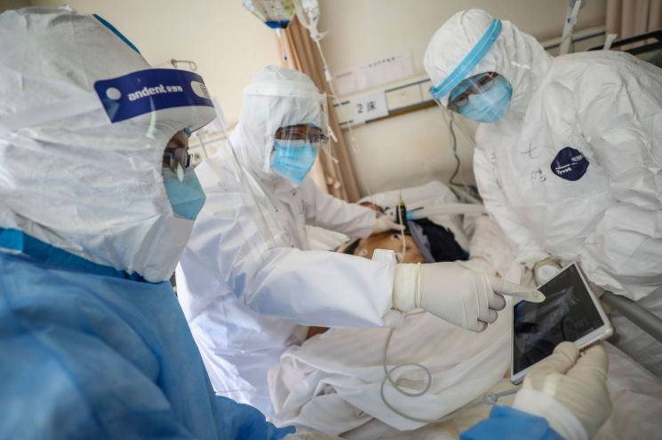 중국 후베이성 우한시 적십자병원에서 16일 방호복을 착용한 의료진이 신종 코로나바이러스 감염증(코로나19) 환자의 폐 사진을 확인하고 있다.<이미지:연합뉴스>