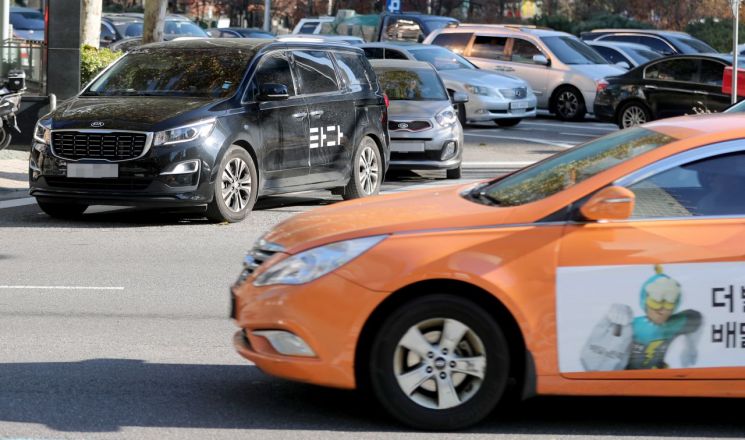 국회 국토교통위원회 전체회의에서 여객자동차운수사업법 개정안, 이른바 '타다 금지법'이 의결된 지난해 12월 6일 오후 서울 마포구 공덕오거리에서 택시가 타다 차량 앞을 지나고 있다. [이미지출처=연합뉴스]