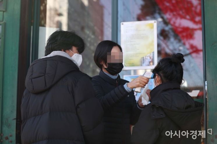 신종 코로나바이러스(코로나19)의 지역사회 확산 가능성이 커지고 있는 23일 서울 종로구 조계사에서 불자들이 대웅전에 들어서기 전 체온 측정을 받고 있다. /문호남 기자 munonam@