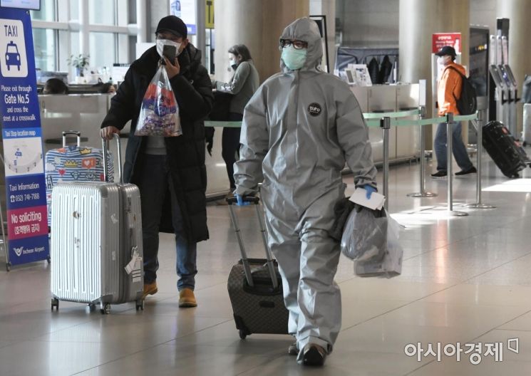 신종 코로나바이러스 감염증(코로나19) 확산세가 급증하고 있는 24일 인천국제공항에서 중국인 여행객이 방역복을 입고 입국장을 빠져나가고 있다./영종도=김현민 기자 kimhyun81@