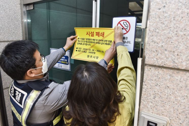 원주시와 경찰이 지난달 29일 코로나19 확진자가 발생한 원주시 우산동과 태장동 지역 신천지 교회 예배당 등 시설물에 건물 폐쇄 스티커를 부착했다. [이미지출처=연합뉴스]