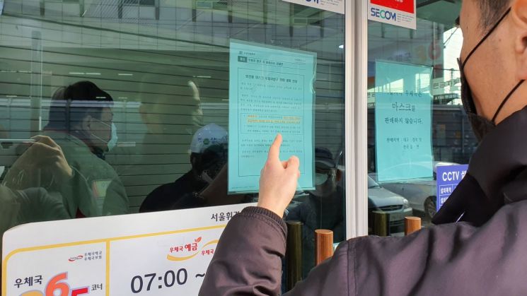 2일 오전 8시30분 서울 동대문구 휘경동우체국 입구에 붙어 있는 마스크 판매 관련 공고문을 한 시민이 읽고 있다.