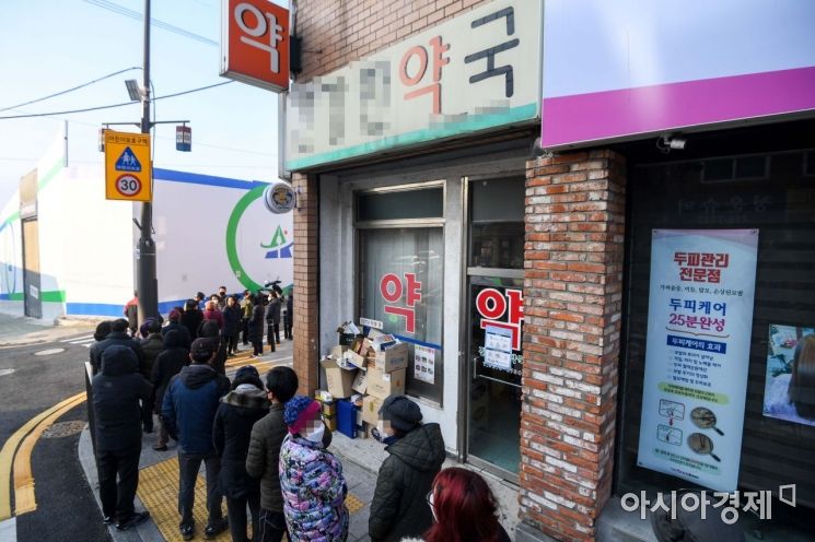 정부가 마스크를 약국에서만 판매하는 방안을 검토하고 있는 4일 서울 용산구 한 약국 앞에서 주민들이 마스크를 구매하기 위해 줄을 서고 있다./강진형 기자aymsdream@