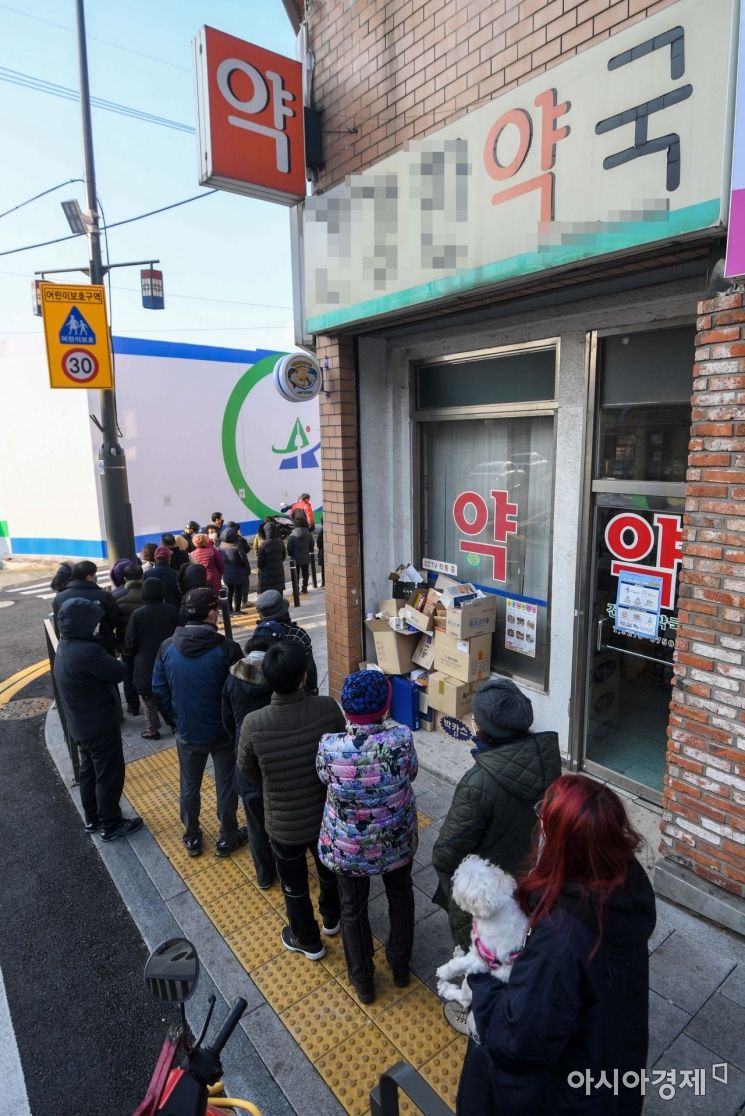 정부가 마스크를 약국에서만 판매하는 방안을 검토하고 있는 4일 서울 용산구 한 약국 앞에서 주민들이 마스크를 구매하기 위해 줄을 서고 있다./강진형 기자aymsdream@