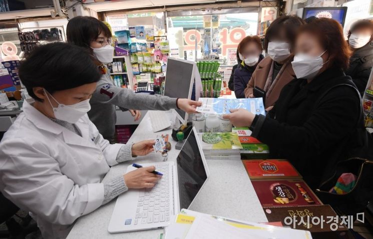 6일 서울 종로5가 인근 약국에서 시민들이 마스크를 구매하고 있다. 이날부터 전국 약국에서는 중복구매 확인시스템이 구축돼 신분증을 제시해야 마스크 구매가 가능하다. 1인당 5매였던 구매한도는 1인당 2매로 줄었다./김현민 기자 kimhyun81@