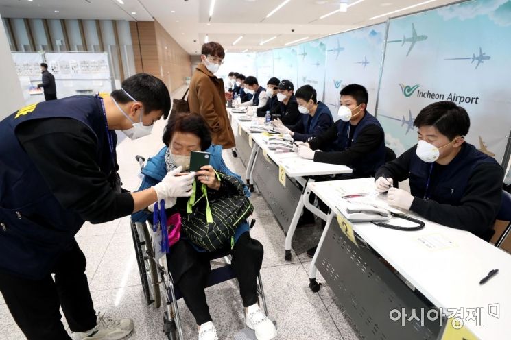 9일 인천국제공항 2터미널에서 일본발 여객기를 타고 도착한 승객들이 자가진단 앱을 휴대전화에 설치하고 있다. /문호남 기자 munonam@