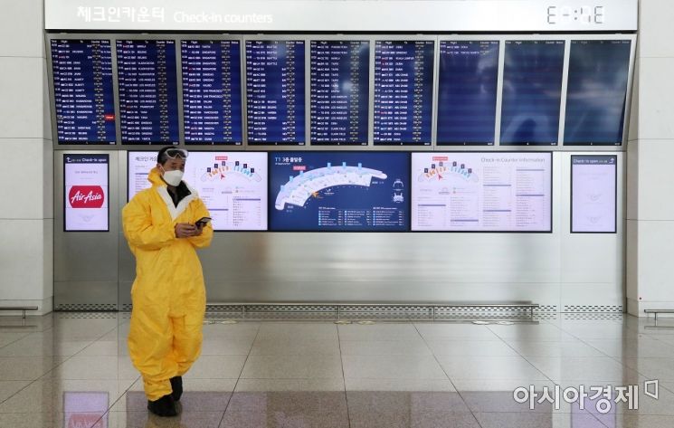9일 인천국제공항 1터미널 출발 알림 전광판 앞으로 방역복을 입은 외국인이 발걸음을 옮기고 있다. /문호남 기자 munonam@