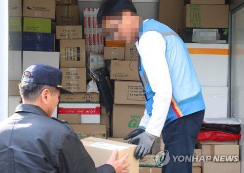 한 아파트 경비원이 택배를 받고 있다. [이미지출처=연합뉴스]
