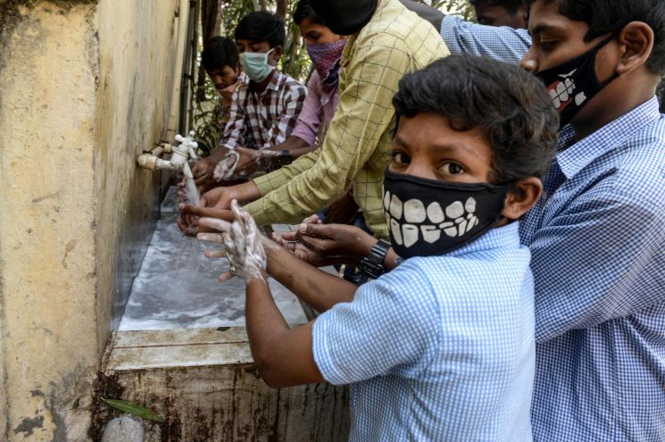 최근 인도의 한 고등학교에서 마스크를 쓴 학생들이 신종코로나바이러스감염증(코로나19) 예방을 위해 수업에 참석하기 전 손을 씻고 있는 모습. [사진=AFP/연합뉴스]