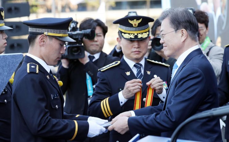 문재인 대통령이 12일 오후 충남 아산시 경찰대학에서 열린 신임경찰 경위.경감 임용식에 참석, 김지수(경찰대) 허준행(간부후보)에게 대통령상을 수여하고 있다. [이미지출처=연합뉴스]