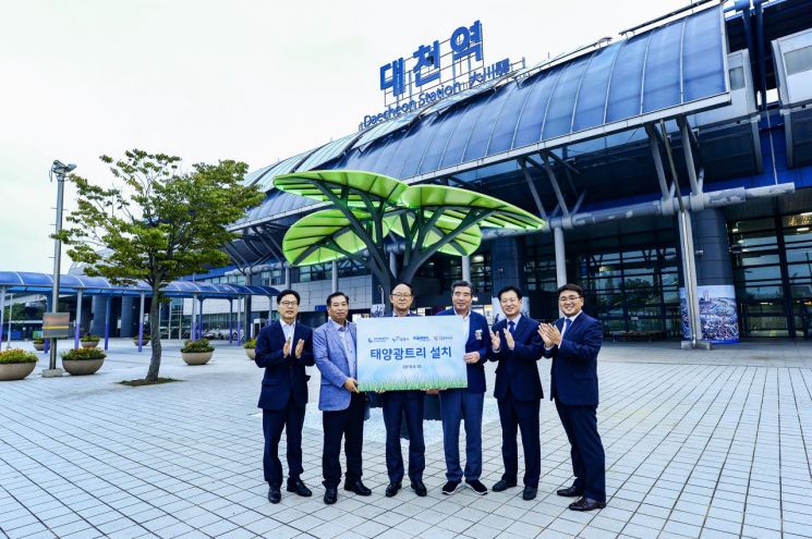 　지난해 9월10일 대천역 광장에 설치된 태양광나무(솔라트리)의 점등을 축하하며 기념사진을 촬영하고 있다. 왼쪽 두 번째부터 김현구 대천역장, 박형구 중부발전 사장, 김동일 보령시장, 최종기 한국에너지재단 사업본부장, 박준영 현대알루미늄 대표이사.(사진=한국중부발전)