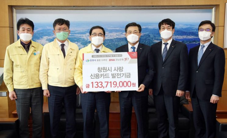 허성무 창원시장(사진 왼쪽에서 세번째)이 13일 김갑수 BNK경남은행 고객지원 그룹장(네번째)에게 기금을 전달받고 있다.