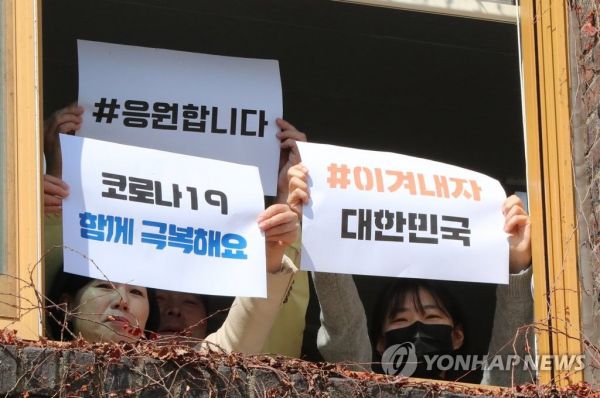지난 5일 오전 광주 북구청에서 구청과 북구의회 직원들이 코로나19 응원 문구가 적힌 종이를 들고 극복을 응원하는 퍼포먼스를 펼치고 있다./사진=연합뉴스