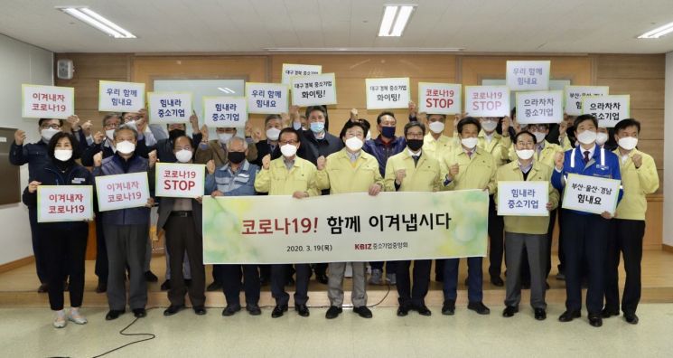 김기문 중소기업중앙회 회장(앞줄 왼쪽 여섯 번째)이 19일 부산 강서구 화전산단 소재 부산시기계공업협동조합을 방문해 중소기업인, 중소기업 지원기관 관계자 등과 코로나19 극복 의지를 다지고 있다.