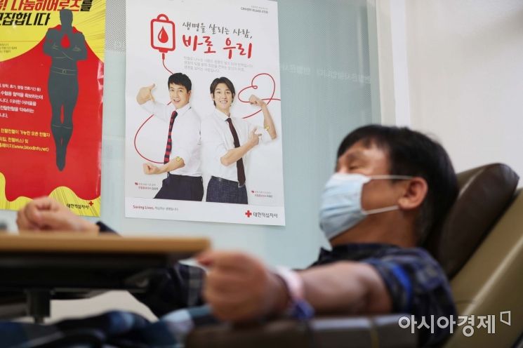 헌혈의 집에서 한 시민이 전혈 헌혈을 하고 있다. 벽에 붙은 대한적십자사 홍보 문구 '생명을 살리는 사람, 바로 우리'가 눈에 띈다. /문호남 기자 munonam@
