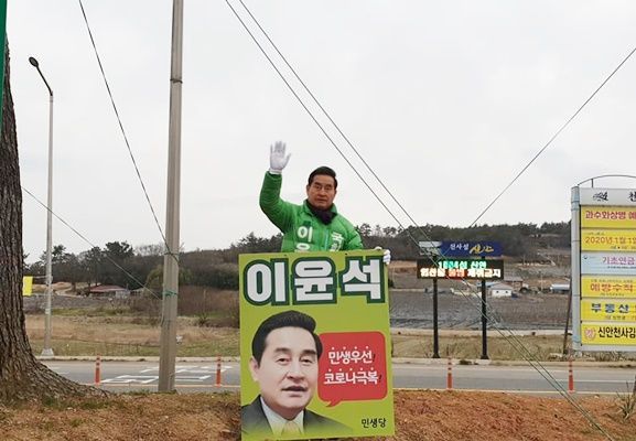 민생당 이윤석 후보가 신안군 압해도에서 지나는 차량에 손을 흔들고 있다.