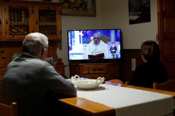 신자들이 TV를 통해 프란치스코 교황의 강론을 시청하고 있다. [이미지출처=로이터연합뉴스]