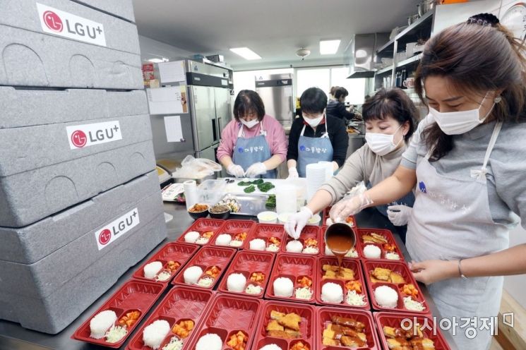 LG유플러스는 코로나19 확산 및 학교개학 연기로 위기에 처한 급식 납품 농가의 친환경 농산물을 공동 구매하고, 용산구 저소득층 아동들에게 도시락을 지원한다. 후암동 로컬기업 ‘마을밥상’ 직원들이 아이들에게 제공할 도시락과 간식을 준비하고 있다.