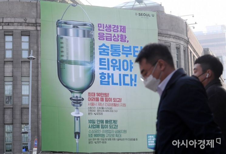 지난달 31일 서울 중구 서울도서관 외벽에 서울시 재난 긴급생활비 지원 안내 현수막이 걸려 있다. /김현민 기자 kimhyun81@