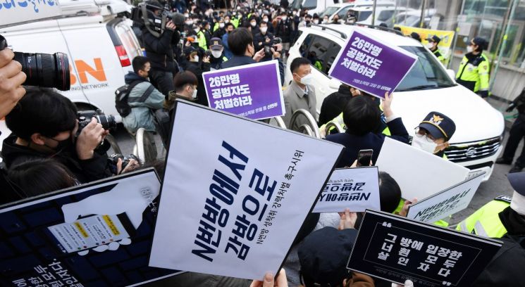 지난 25일 인터넷 메신저 텔레그램에서 미성년자를 포함한 여성들의 성 착취물을 제작 및 유포한 혐의를 받는 '박사방' 운영자 조주빈이 탄 차량이 서울 종로경찰서를 나와 검찰 유치장으로 향하자 시민들이 조주빈의 강력처벌을 촉구하며 피켓 시위를 하고 있다. [이미지출처=연합뉴스]